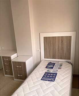 Dormitorio juvenil con escritorio, mesitas de noche, cabecero y armario empotrado a juego.